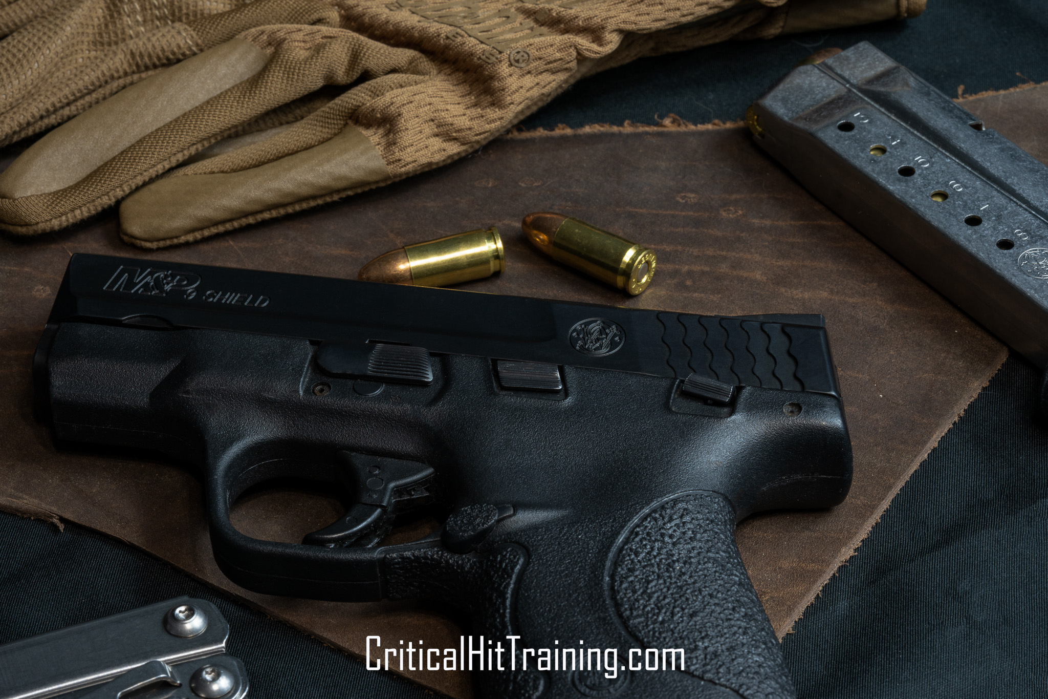 Image of an M&P Shield handgun resting on a textured leather backdrop, highlighting its compact design, matte finish, and ergonomic grip, with warm tones adding a rustic aesthetic.